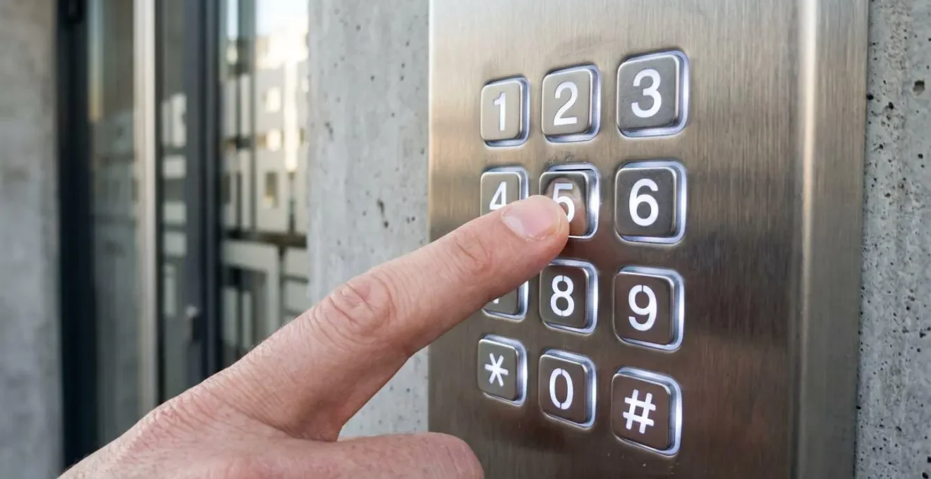 Gros plan sur un clavier numérique moderne avec boutons rétroéclairés, main tapant un code d'accès personnel